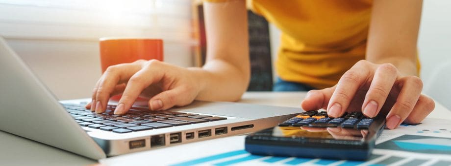 Person using a calculator and a laptop